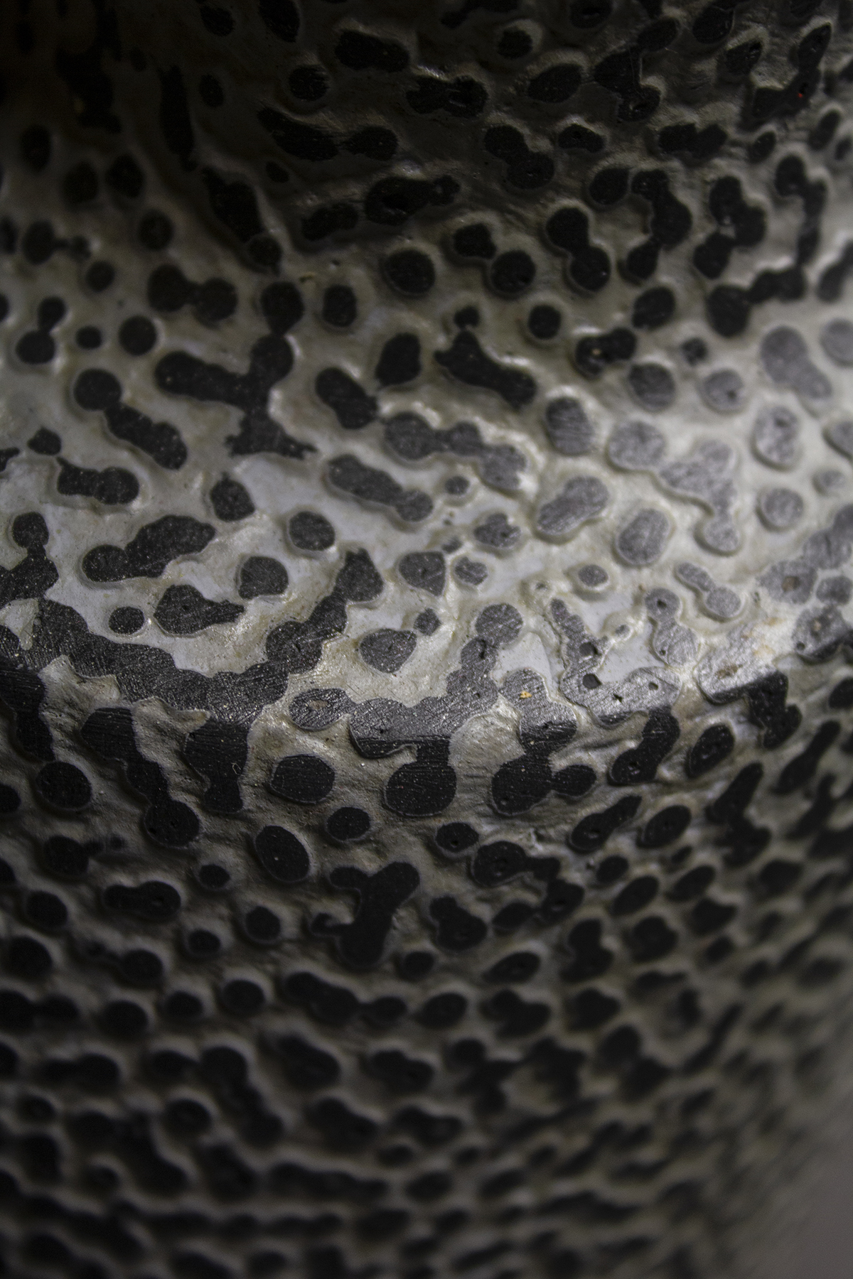 détail de la sculpture, on peut y voir la texture granuleuse et colorée en papier mâché, des motifs géométriques et végétaux