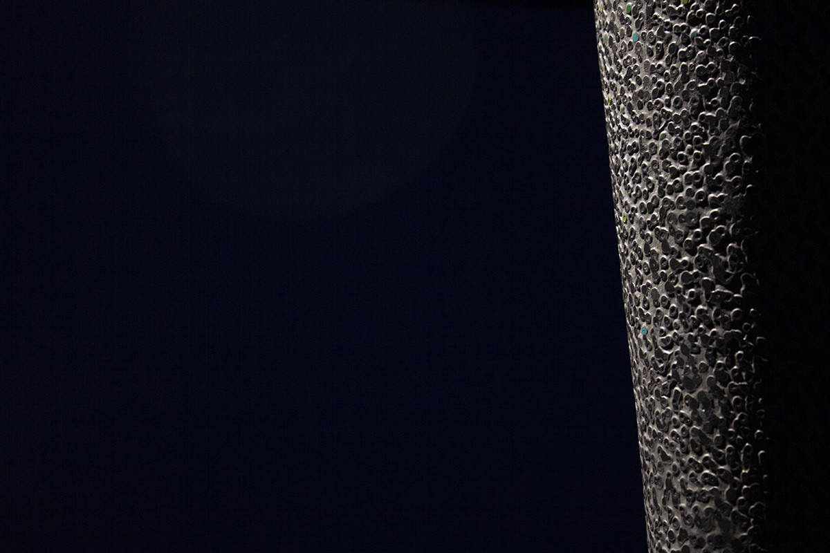 détail de la sculpture, on peut y voir la texture granuleuse et colorée en papier mâché, des motifs géométriques et végétaux